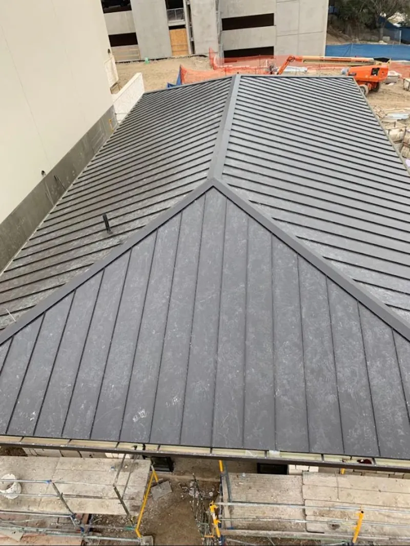 Commercial metal roof construction with crane equipment in King City